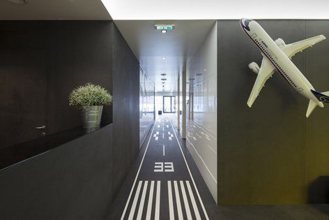 an airplane is flying in the air above a hallway with black walls and white lines