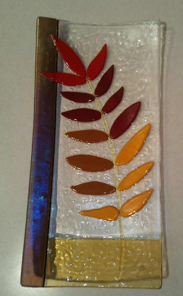 a piece of art that has been made to look like a glass with leaves on it