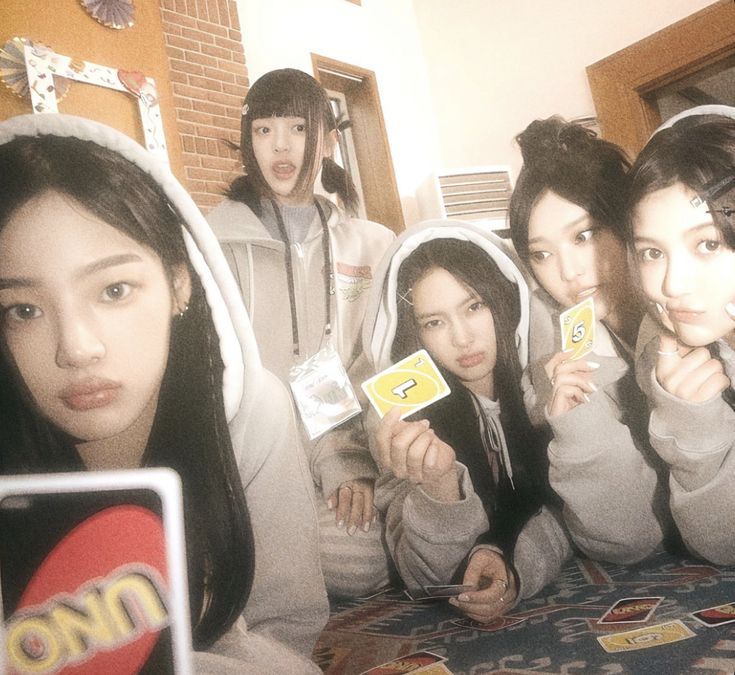 group of young women holding up cards in front of their faces