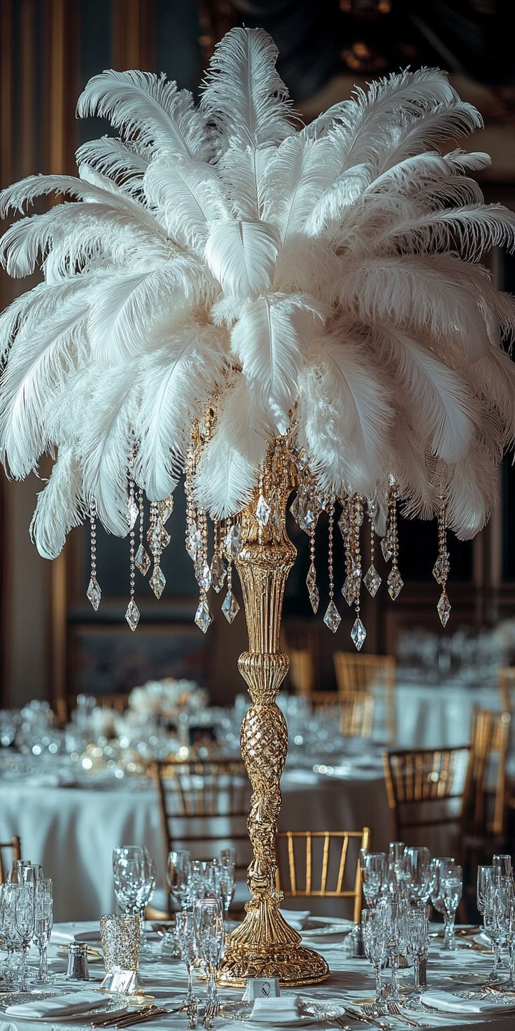 the centerpiece is decorated with white feathers and crystal beaded chandeliers,