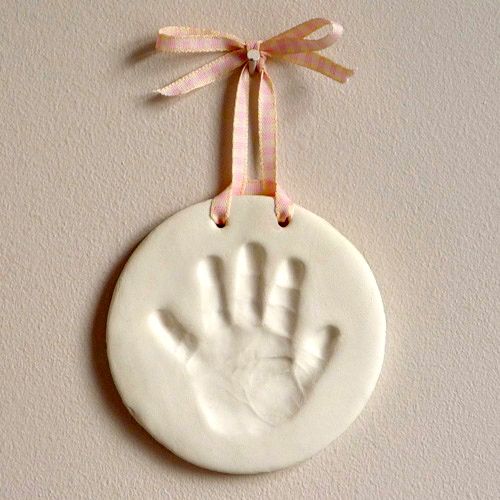 a white ceramic ornament with a hand print on it