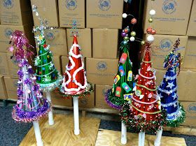 three small christmas trees are on display in front of boxes