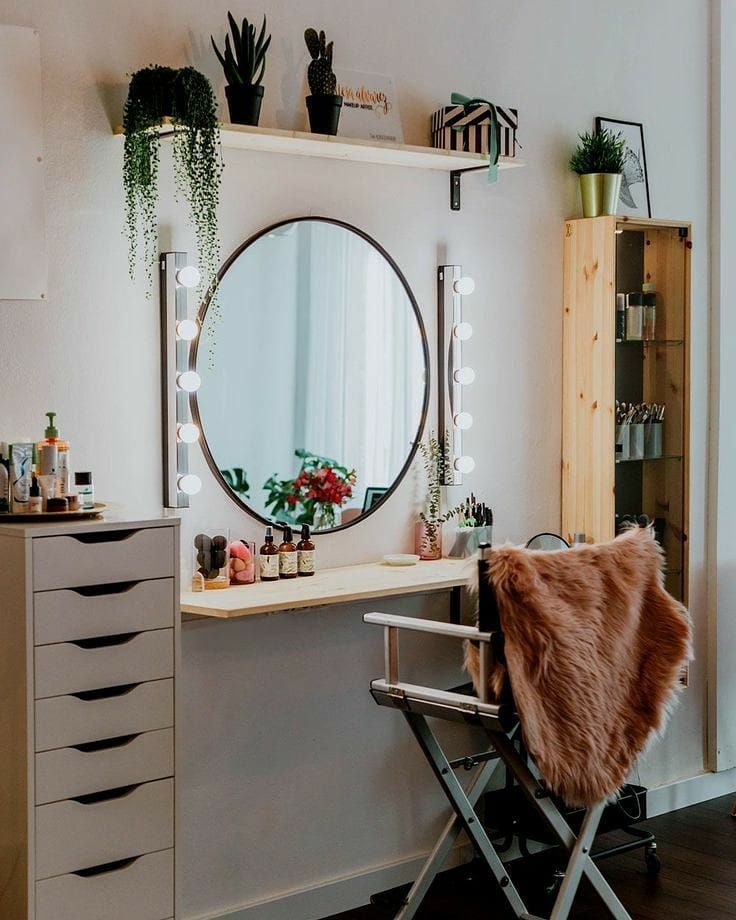 a room with a mirror, dresser and plants