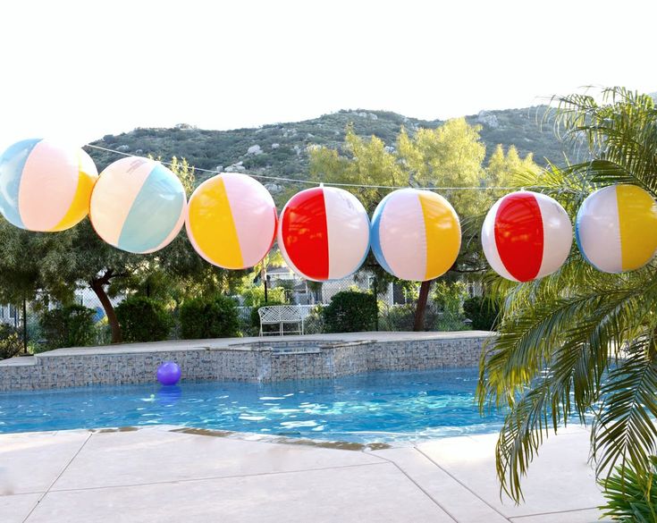 colorful beach balls hanging over a swimming pool