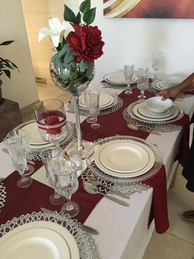 the table is set with white plates and red napkins