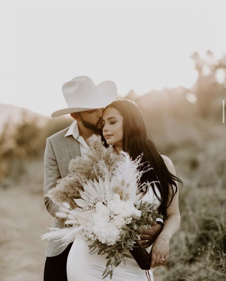 a bride and groom standing together in the desert