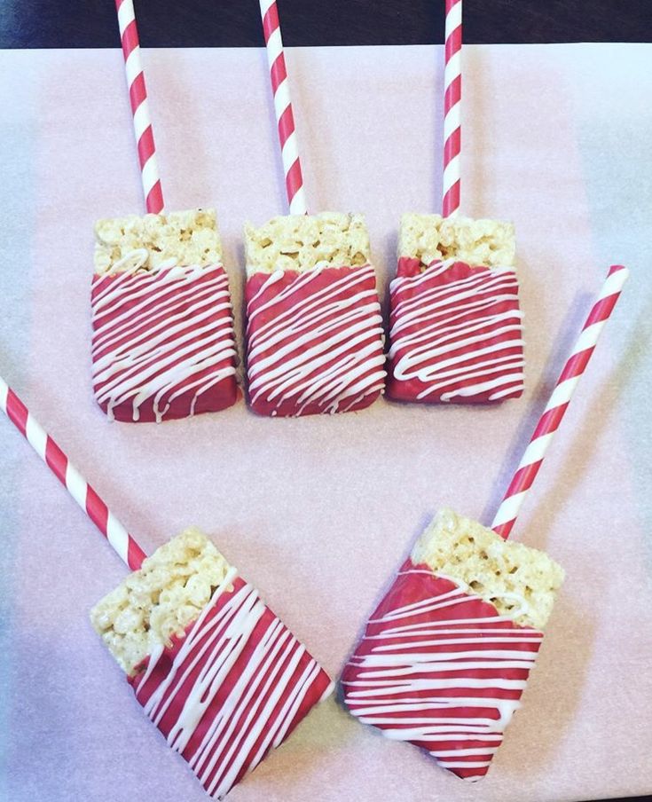 four red and white striped straws with popcorn in them