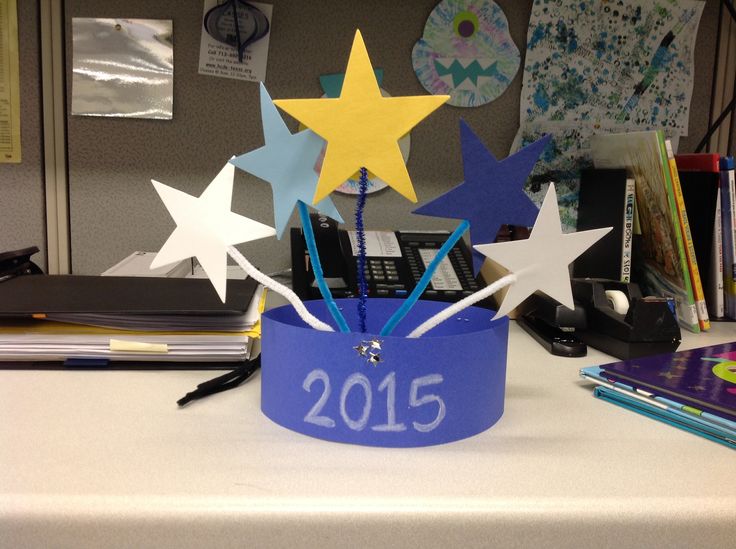 a blue crown with stars on it sitting on top of a white desk next to a pile of books