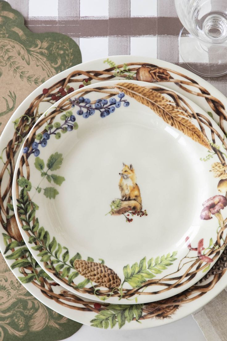 four plates with different designs on them sitting next to each other in front of a checkered tablecloth