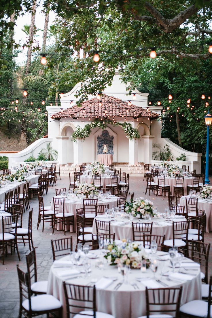 an outdoor wedding venue with tables and chairs