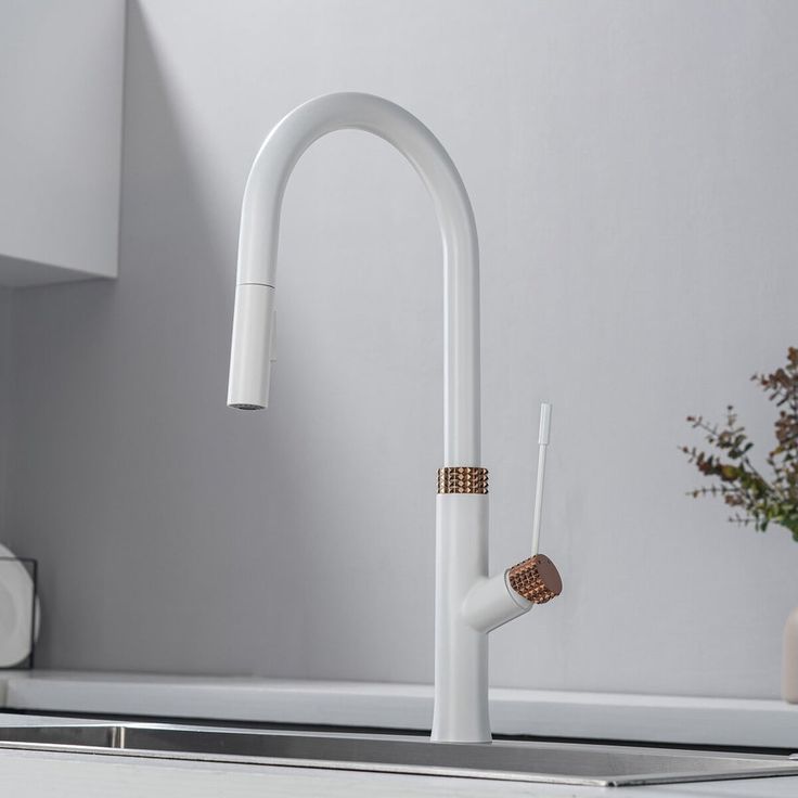 a kitchen sink with a white faucet and wooden handles