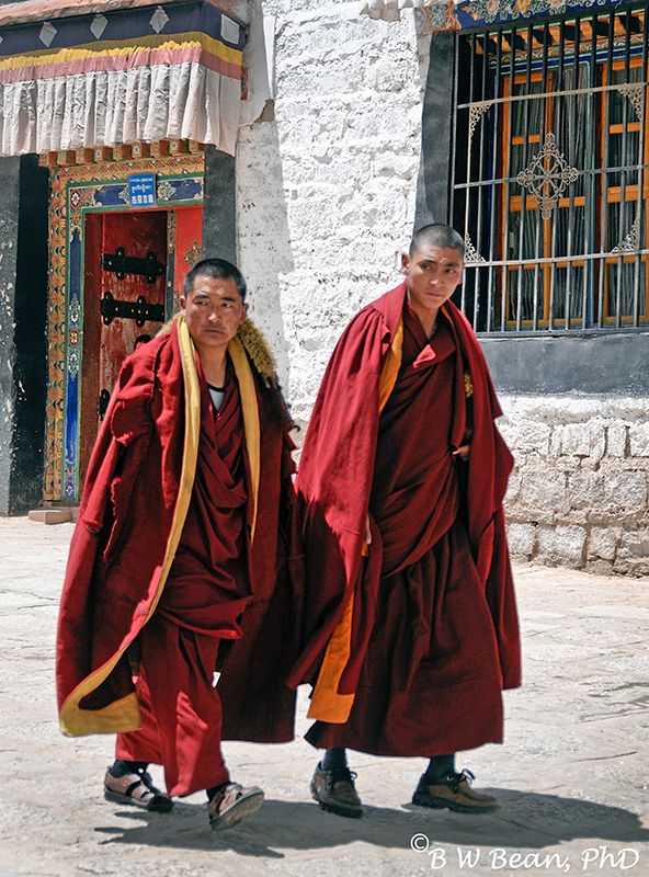 two men in red robes walking down the street