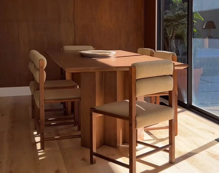 a dining room table and chairs in front of a sliding glass door