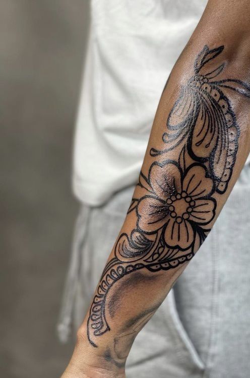 a man with a flower tattoo on his arm