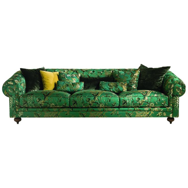 a green couch with many pillows on it