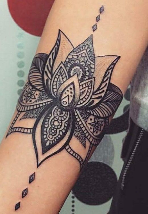 a woman's arm with a flower tattoo on the side of her arm and an arrow in the middle