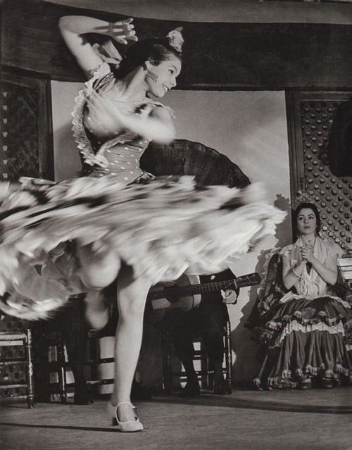 an old photo of a woman dancing with her legs spread out in front of her