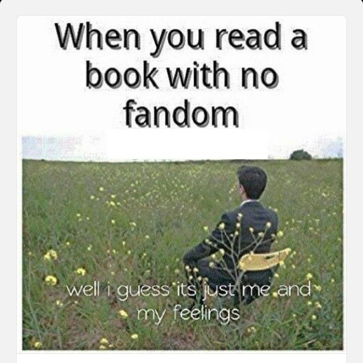 a man sitting in the middle of a field next to a book with no fandom written on it