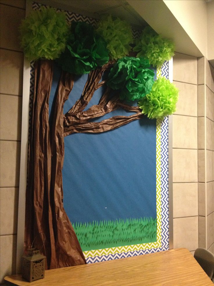 a tree made out of tissue paper sitting on top of a table next to a wall