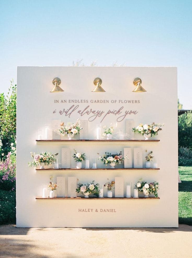 a white sign with flowers and candles on it