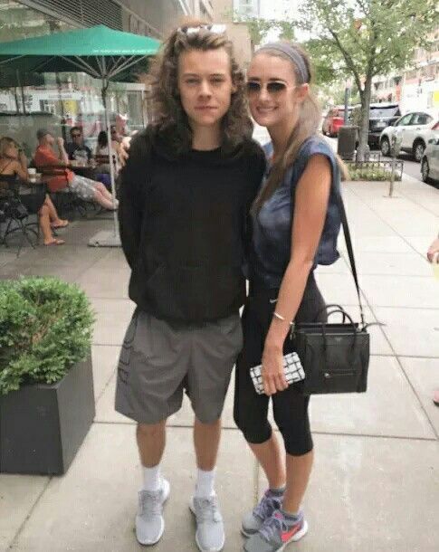 a man and woman standing next to each other on a sidewalk