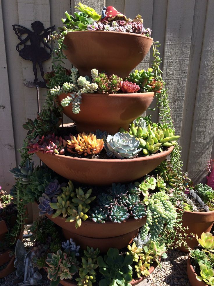 there are many succulents in the pots on this planter tower that is very tall