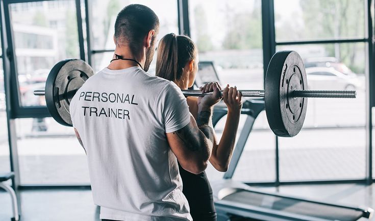 a man and woman lifting weights in a gym