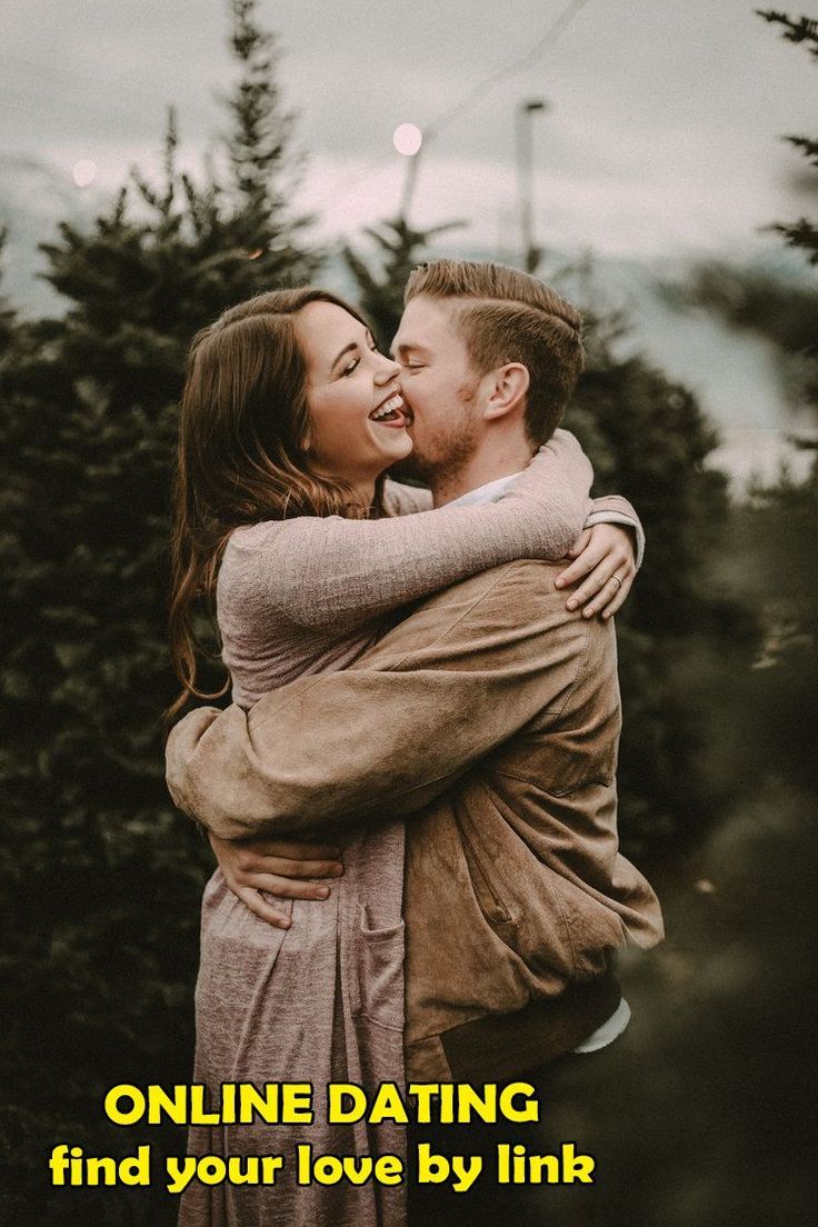 a man and woman embracing each other in front of trees