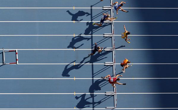 several people are running on a blue track