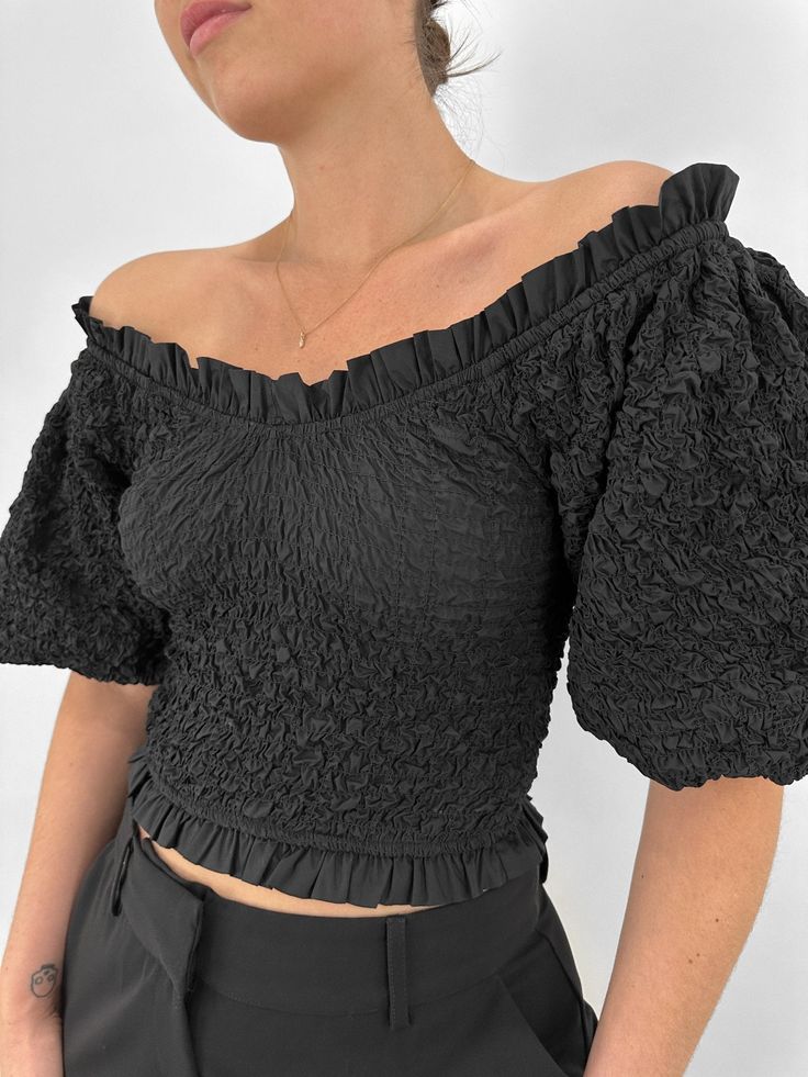 A fun, versatile puff sleeve top, featuring voluminous sleeves, a flattering V-neckline, and flutter trim. The fully smocked elastic throughout ensures a comfortable, yet fitted true-to-size fit that can be worn on or off the shoulder. With its slightly cropped design, this top is perfect for pairing with high-waisted trousers or skirts. Self: 100% Cotton.Lining: 100% Cotton. Connor is wearing size Small. Refer to our Size Chart for Model Measurements. Questions about fit? Text us anytime! 614-3 Chic V-neck Smocked Top With Ruffles, Billowy Smocked Top With Balloon Sleeves, Trendy Puff Sleeve Top With Ruffles For Brunch, Chic Peasant Top With Puff Sleeves And Smocked Cuffs, Billowy Top With Balloon Sleeves And Smocked Back, Fitted V-neck Smocked Top With Ruched Detail, Fall V-neck Ruched Smocked Top, Balloon Sleeve Top With Smocked Back, Billowy V-neck Top With Ruffles