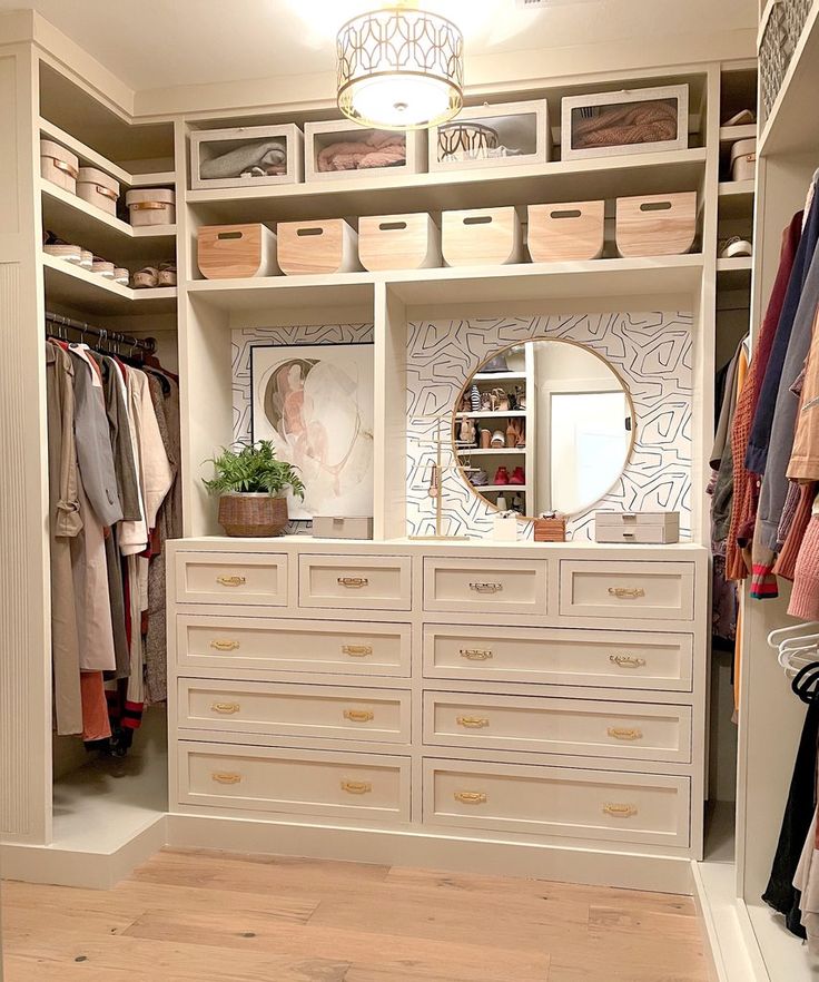 an organized closet with white drawers and gold handles