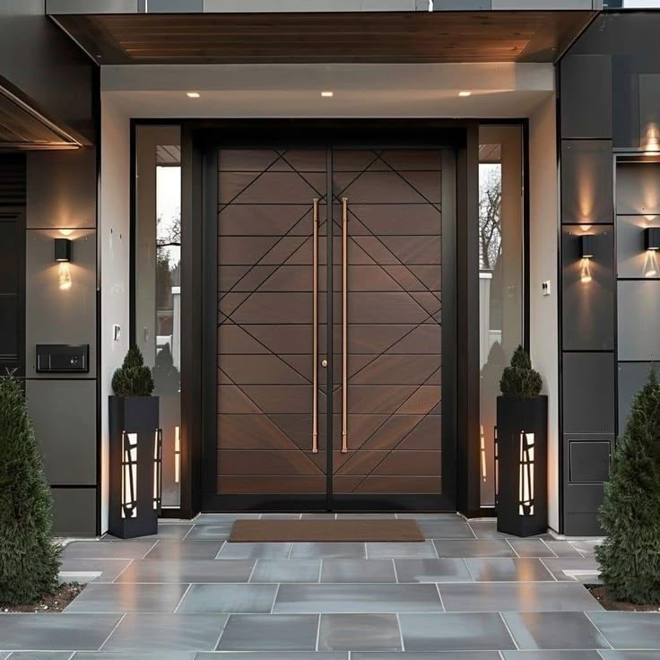 a modern entrance with two planters and lights