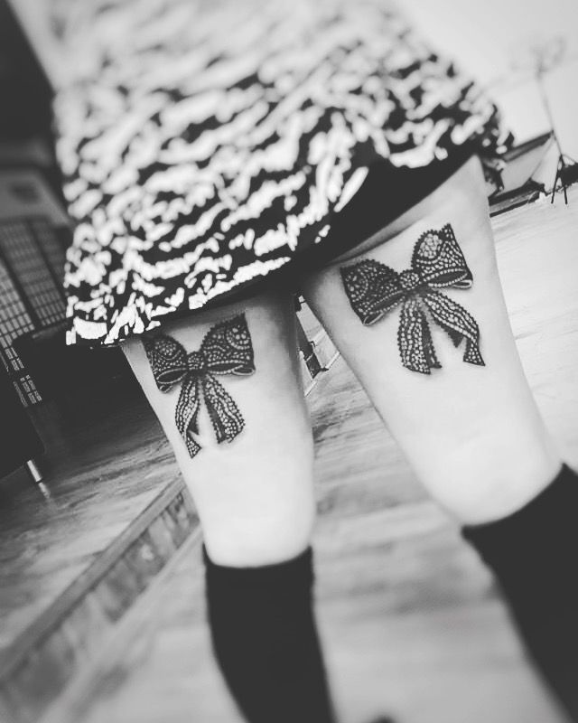 two legs with bow tattoos on them