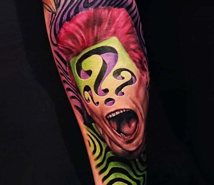 a man's arm with a colorful tattoo on it and an animal face in the middle