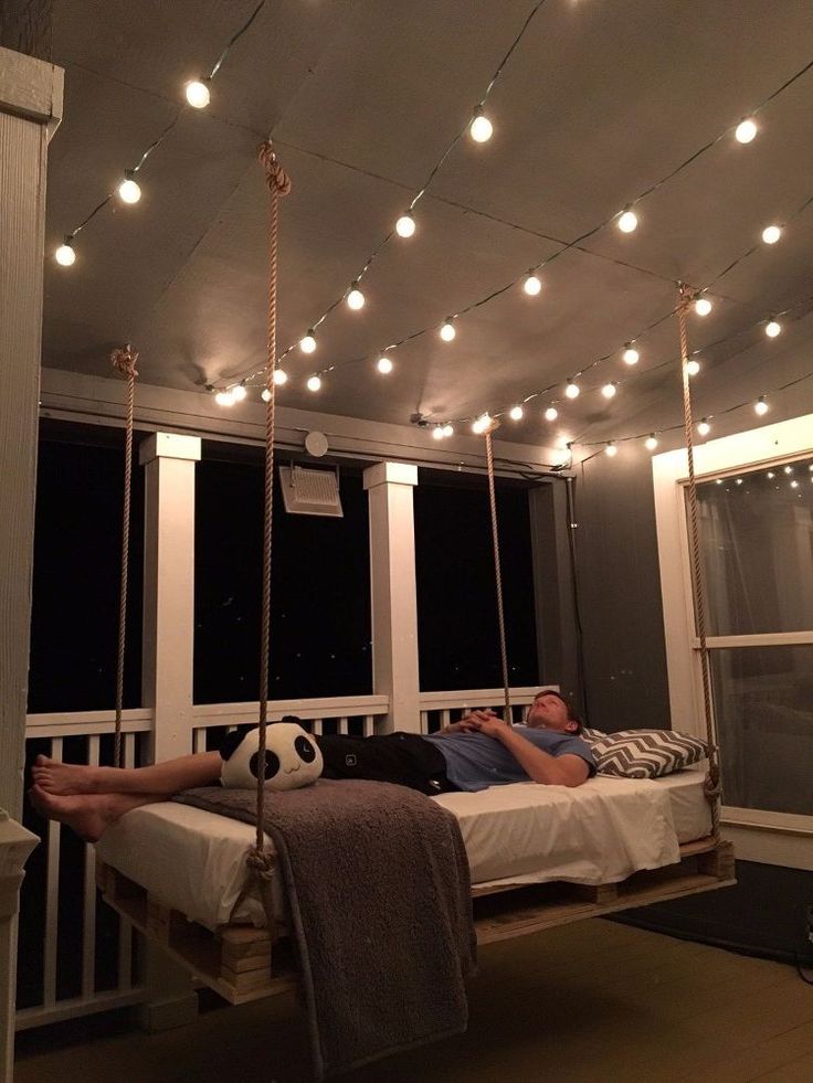 a man laying on a porch swing with a soccer ball hanging from it's side