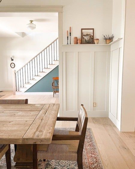 a wooden table sitting in the middle of a living room next to a stair case