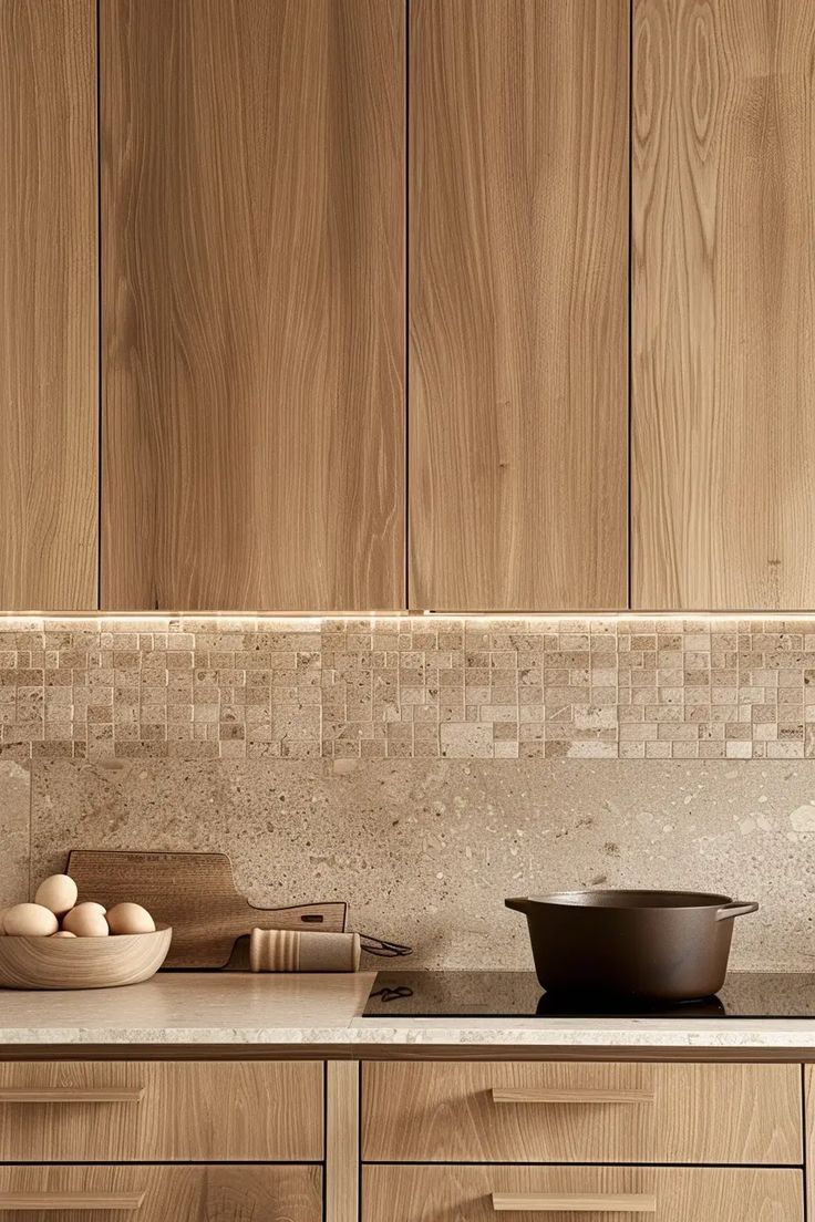 a kitchen with wooden cabinets and bowls on the counter top next to an egg frying pan