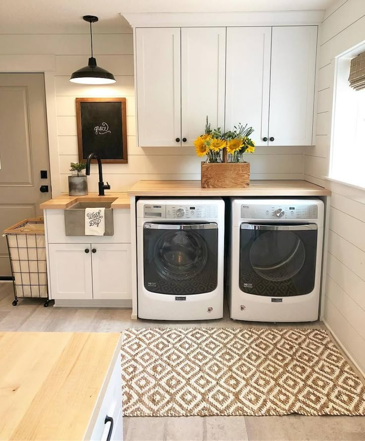 a washer and dryer sitting in a kitchen next to each other on top of a rug