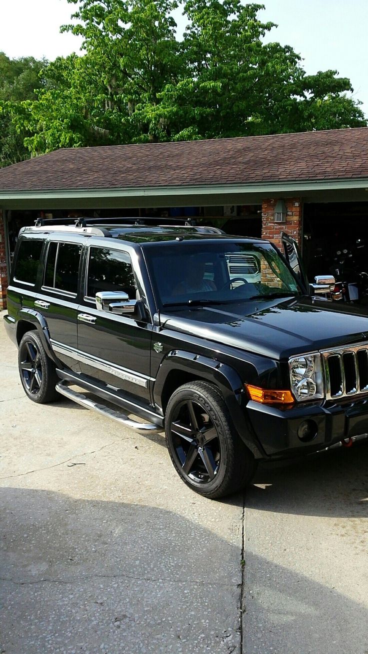 a black jeep parked in front of a garage