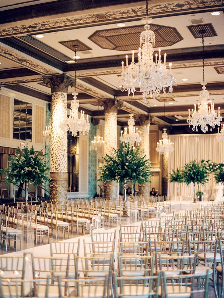 an empty banquet hall with chandeliers and chairs set up for a formal function