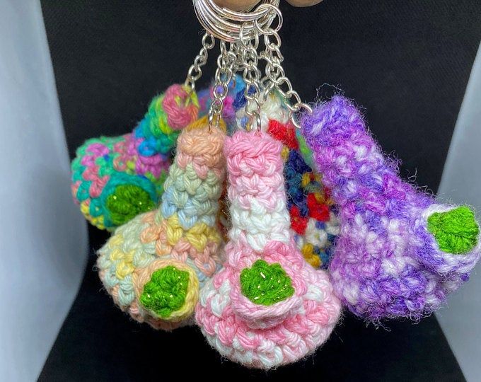 several crocheted items are hanging from a keychain