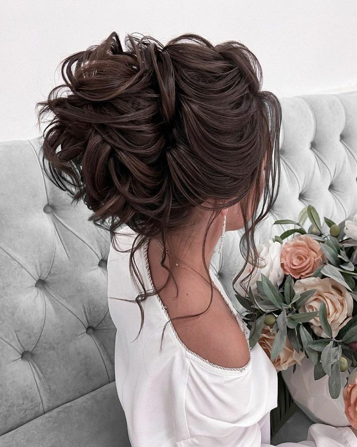 a woman sitting on top of a couch holding a bouquet of flowers