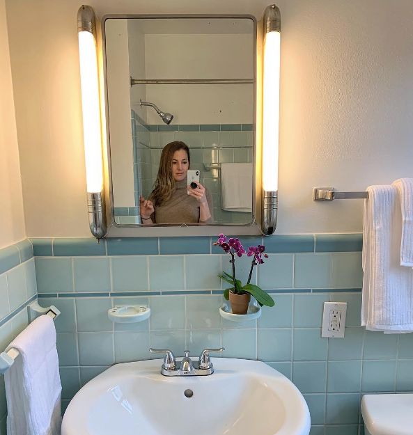 a woman is taking a selfie in the bathroom mirror while holding her cell phone