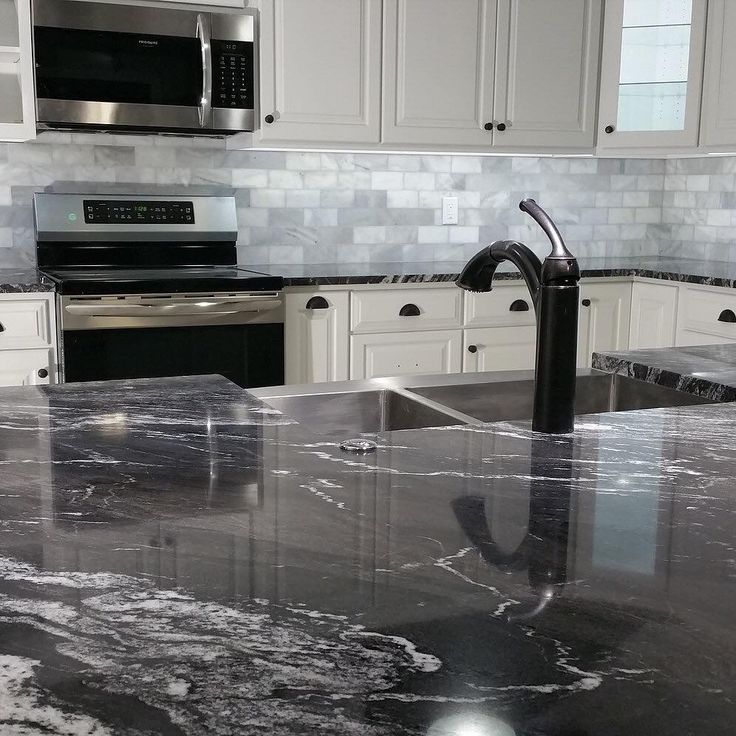 a kitchen with marble counter tops and stainless steel appliances