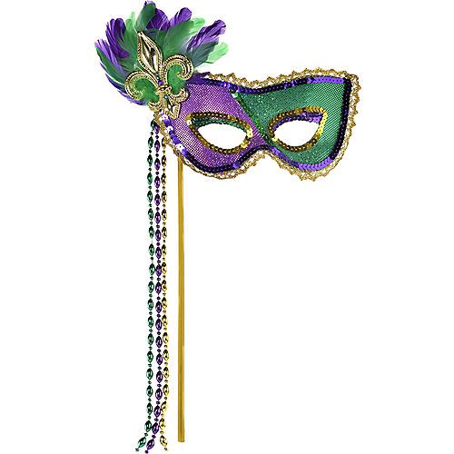 a mardi gras mask on a stick with beads