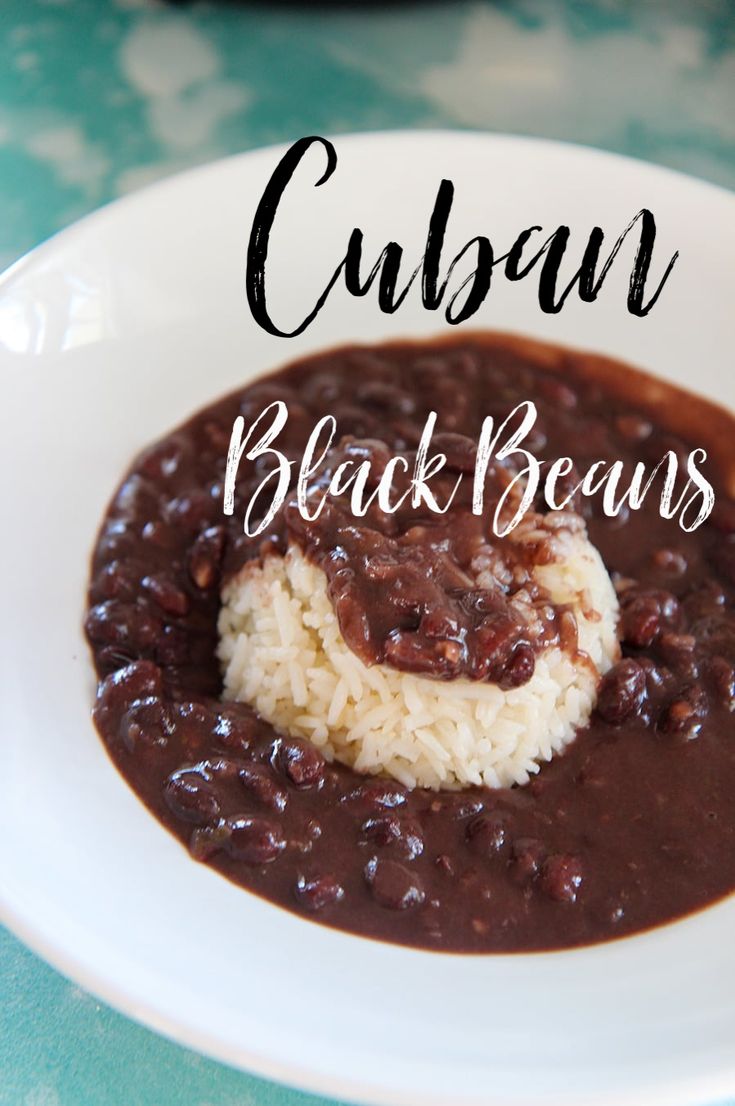 a white plate topped with beans and rice next to a cup filled with chocolate sauce