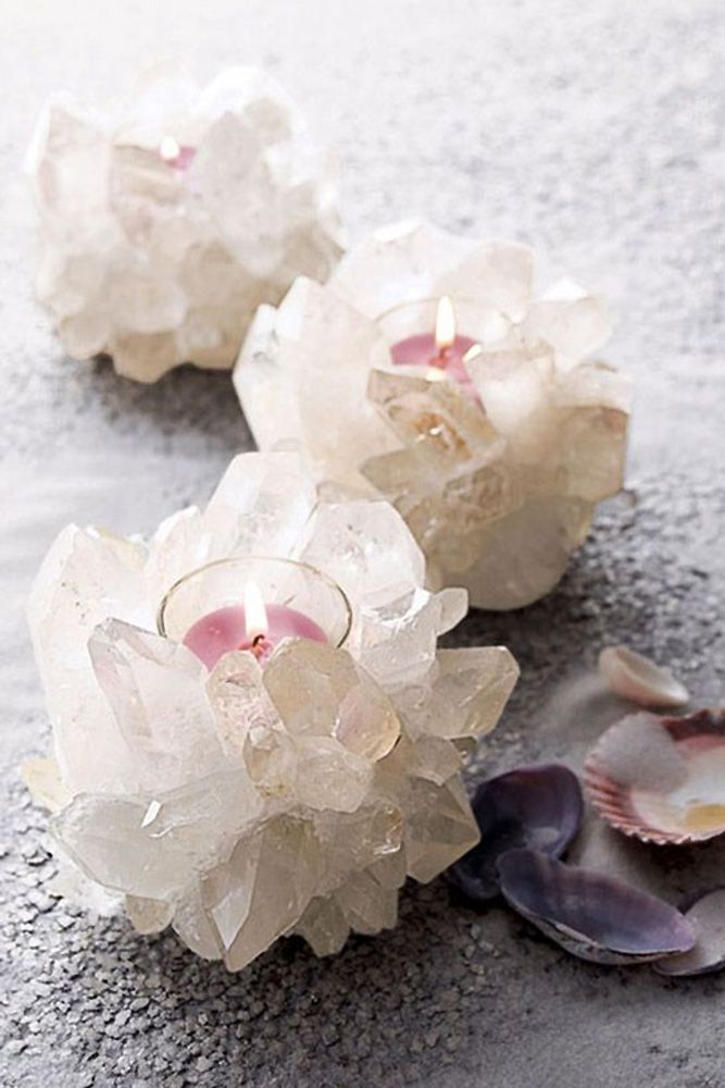 three glass flowers sitting on top of a sandy beach