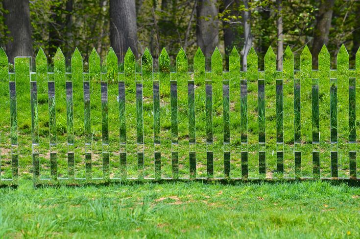 the fence is made of metal rods and grass