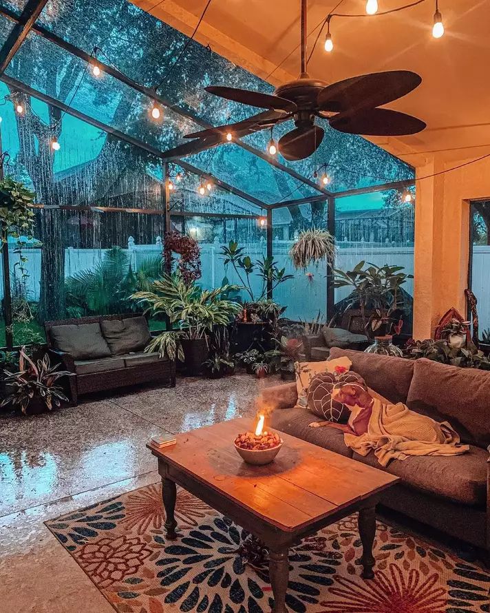 a living room filled with furniture and lots of lights hanging from the ceiling above it