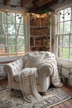 a living room filled with lots of furniture next to two large windows covered in blankets